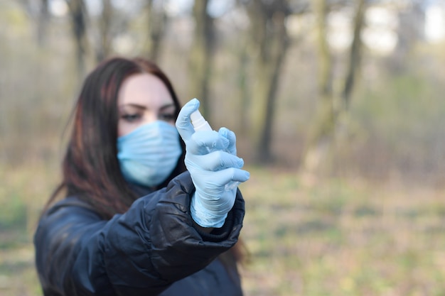 Jeune femme, dans, masque protecteur, montre, désinfectant, vaporisateur, bouteille