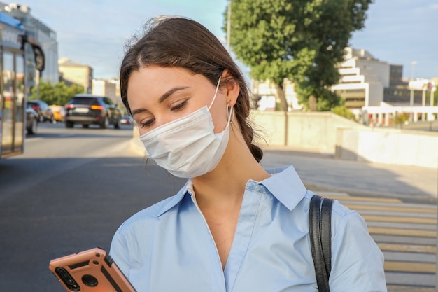 Jeune femme dans un masque de protection avec un téléphone