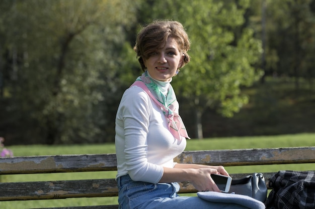 Jeune femme dans le parc parle par téléphone portable Portrait de jolie fille à la française