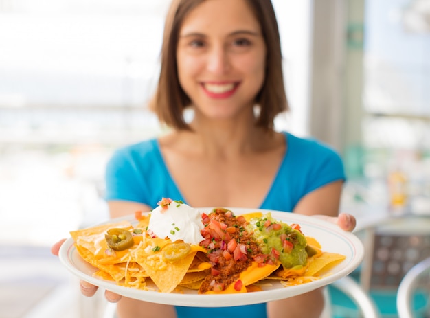 jeune femme dans un restaurant ayant des nachos