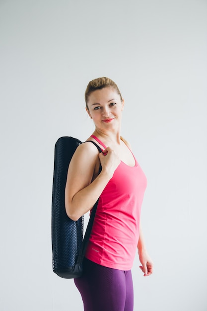 Jeune femme dans une salle blanche venue au yoga