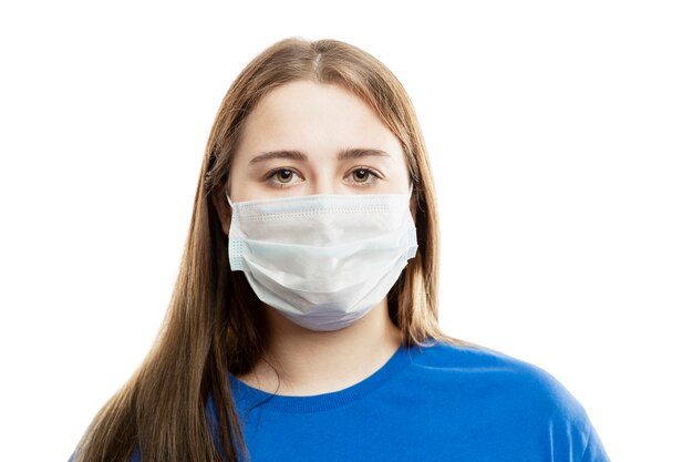 Une jeune femme dans un T-shirt bleu dans un masque médical sur son visage