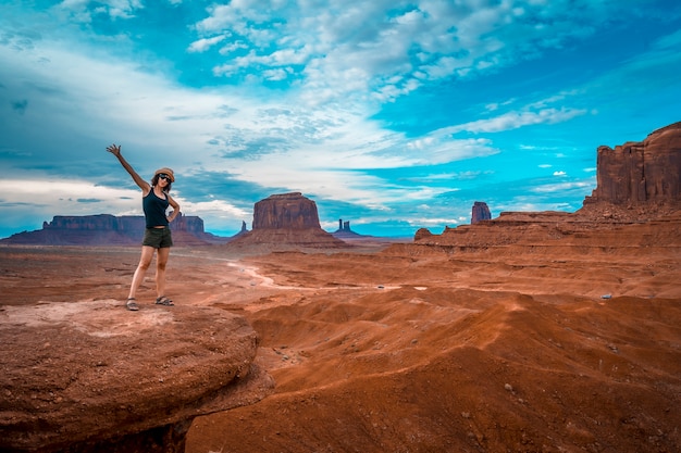 Une jeune femme dans un T-shirt noir à John Ford's Point regardant la Monument Valley.