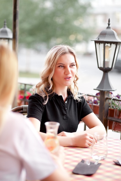 Jeune femme dans une terrasse de café avec des amis.