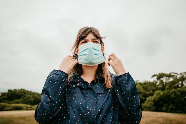 Jeune femme dans une veste avec un masque médical