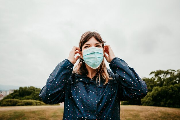 Jeune femme dans une veste avec un masque médical