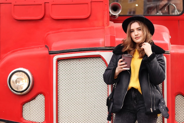 Jeune femme dans des vêtements chauds et élégants se promène dans la ville de printemps