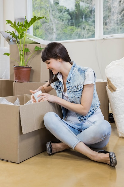 Jeune femme déballant des cartons dans une nouvelle maison