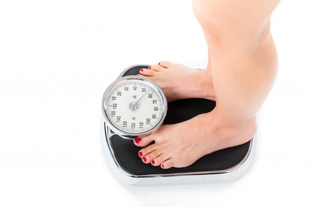 Jeune femme debout sur une balance