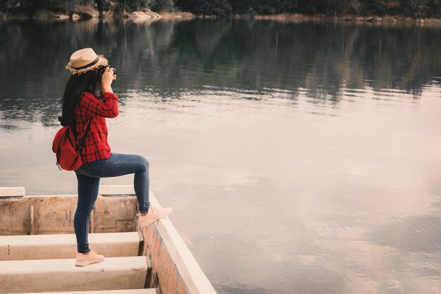 Une jeune femme debout sur un bateau amarré dans le lac