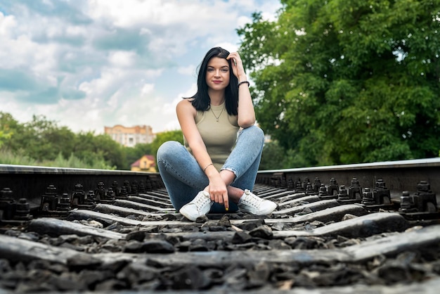 Jeune femme debout sur un chemin de fer, voyage en train en vacances d'été.