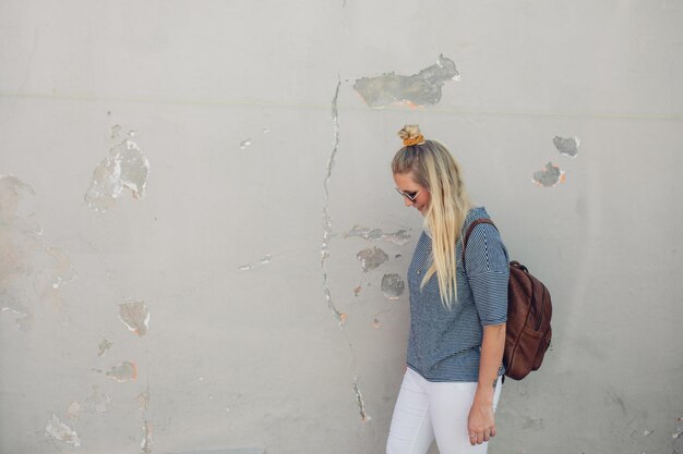 Photo une jeune femme debout contre le mur.