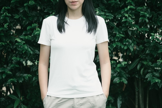 Une jeune femme debout contre des plantes