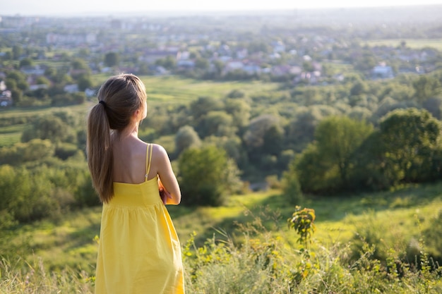 Jeune Femme Debout Dans Le Champ Vert Appréciant La Vue Du Coucher Du Soleil Dans La Nature Du Soir. Concept De Relaxation Et De Méditation.