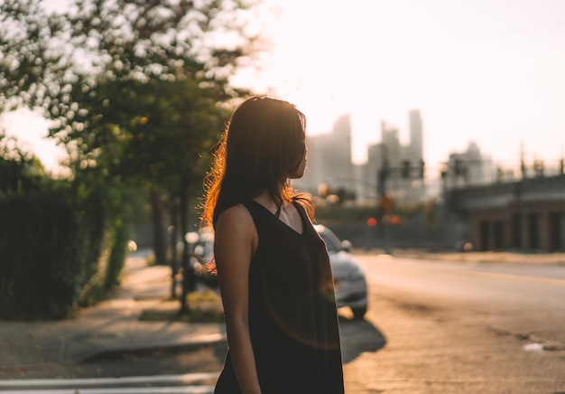 Une jeune femme debout dans la rue de la ville contre le ciel