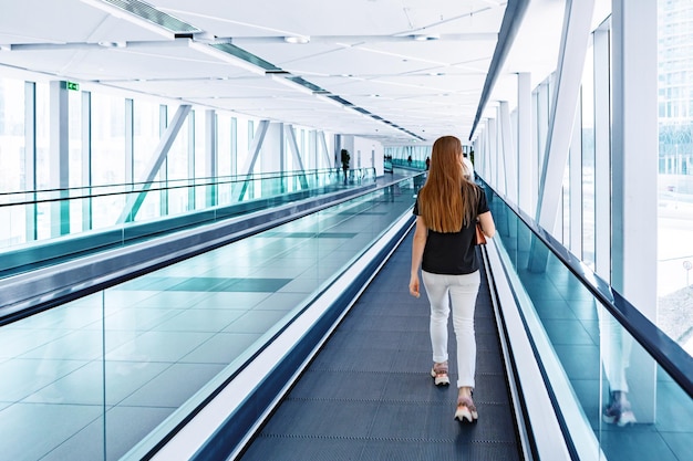 Jeune femme debout à l'escalator dans le métro