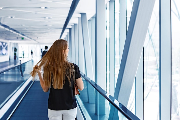 Jeune femme debout à l'escalator dans le métro