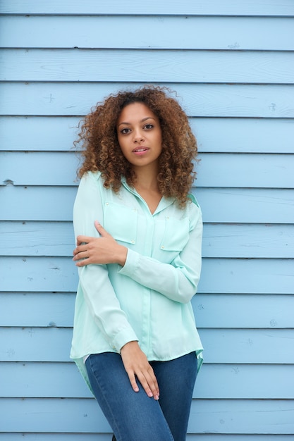 Jeune femme debout à l&#39;extérieur sur fond bleu