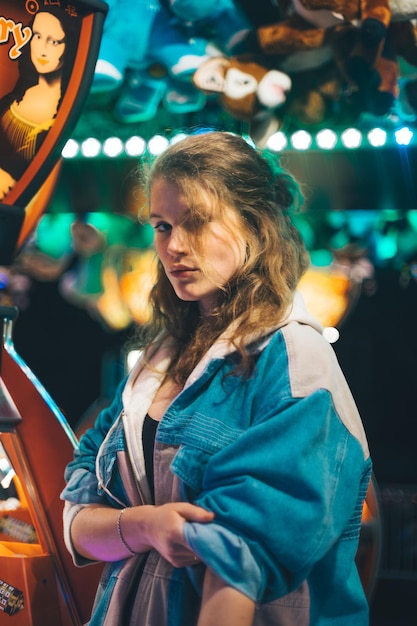 Une jeune femme debout à l'extérieur la nuit.