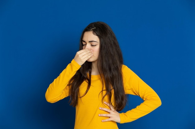 Photo une jeune femme debout sur un fond bleu