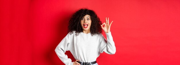 Photo une jeune femme debout sur un fond jaune