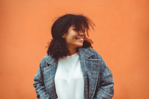 Jeune femme debout sur fond orange