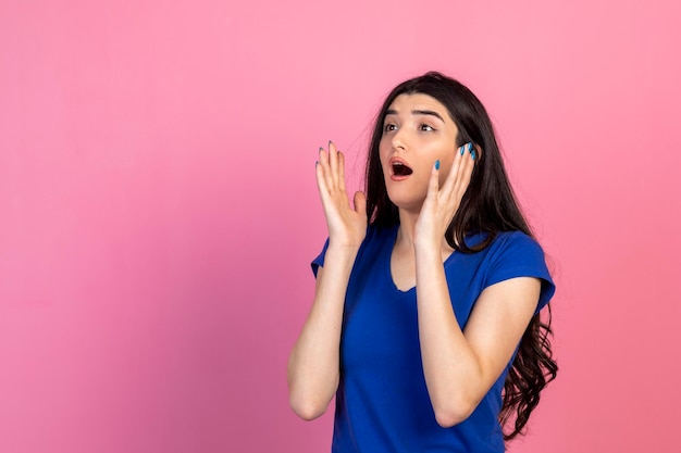 Jeune femme debout sur fond rose et criant Photo de haute qualité