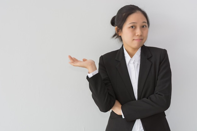 Jeune femme debout isolé sur un mur gris naviguant sur internet sur tablette numérique souriant joyeux