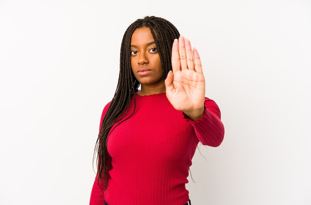 Jeune femme debout avec la main tendue montrant le panneau d'arrêt