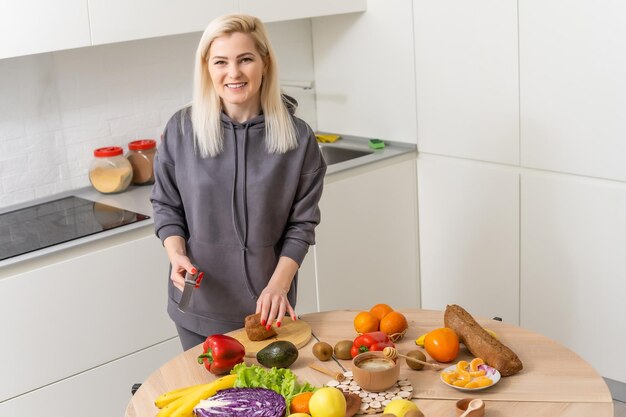 Jeune femme debout près du bureau dans la cuisine.