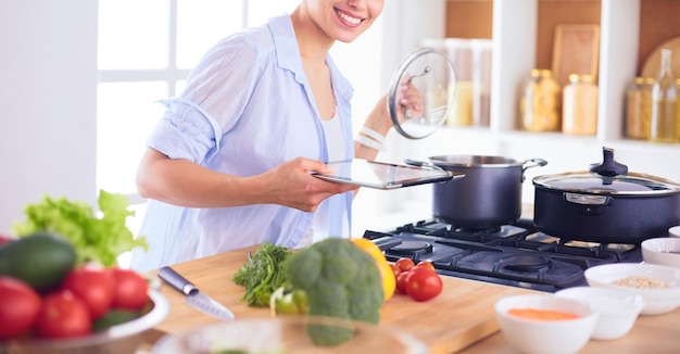 Jeune femme debout près du poêle dans la cuisine