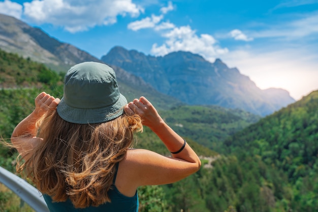 Jeune femme debout seule à l'extérieur avec des montagnes de la forêt sauvage en arrière-plan