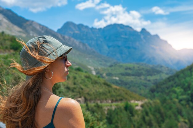 Jeune femme debout seule à l'extérieur avec des montagnes de la forêt sauvage en arrière-plan