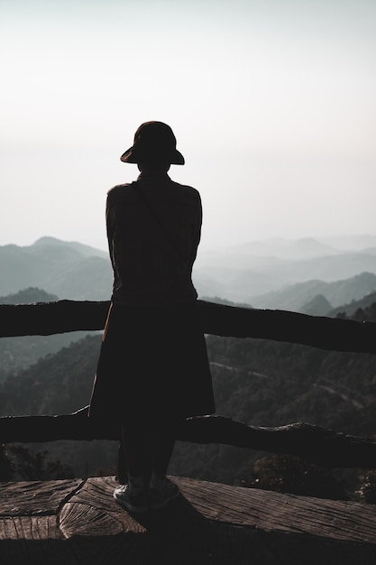 Jeune femme debout seule en plein air avec des montagnes de la forêt sauvage en arrière-plan