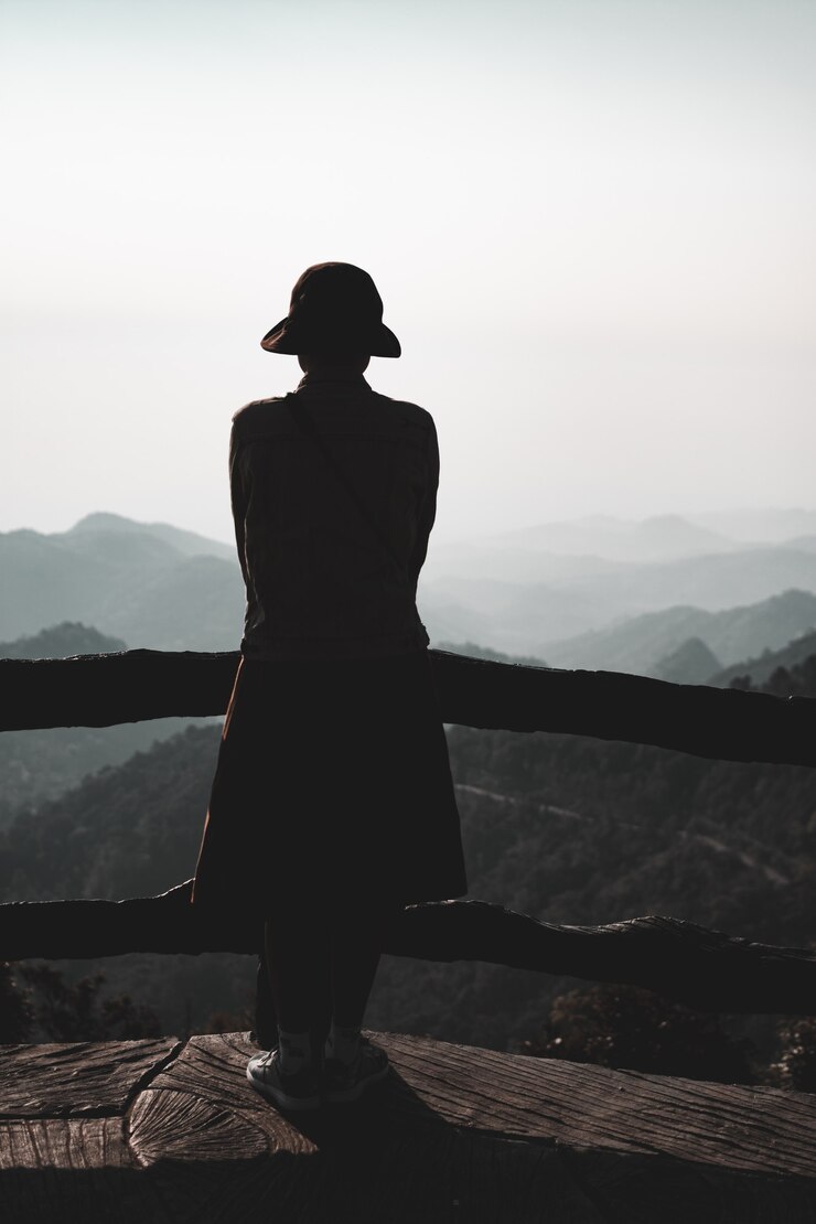 Photo jeune femme debout seule en plein air avec des montagnes de la forêt sauvage en arrière-plan