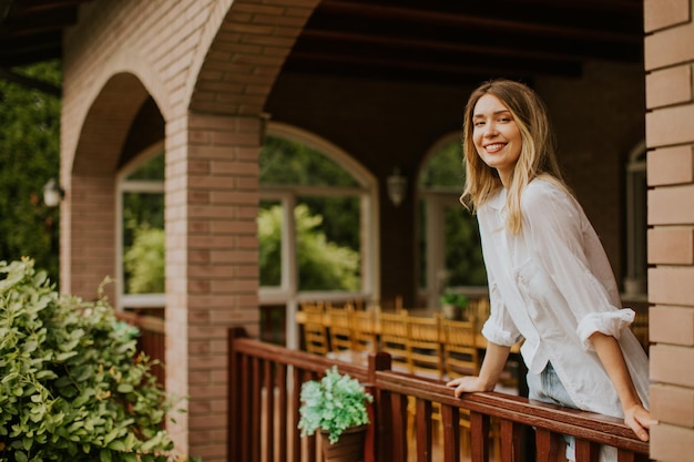 Jeune femme debout sur la terrasse