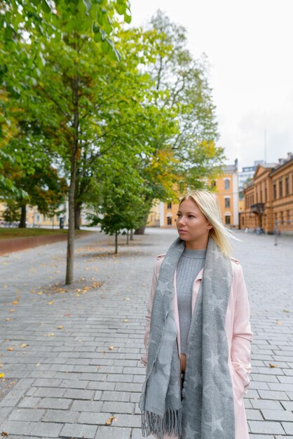 Une jeune femme debout sur le trottoir de la rue en ville