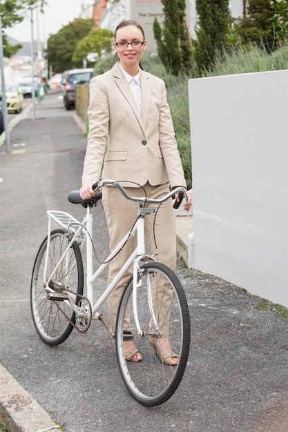 Jeune femme debout avec vélo