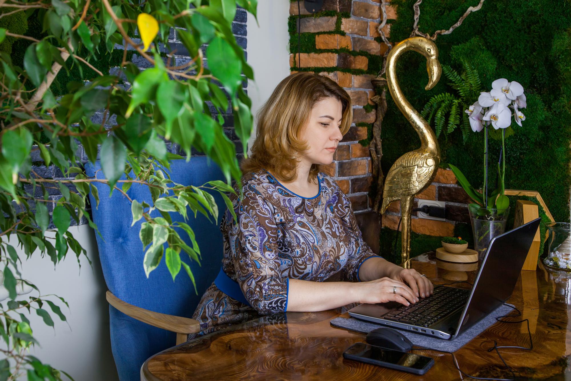 Une jeune femme décoratrice d'intérieur travaille dans son bureau sur un ordinateur Bureau vert