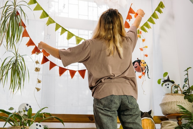 Photo jeune femme décorer la maison pour halloween intérieur de la maison décorée pour halloween avec bricolage