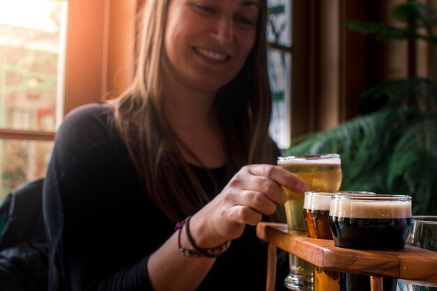 Photo une jeune femme dégustant de la bière artisanale au bar