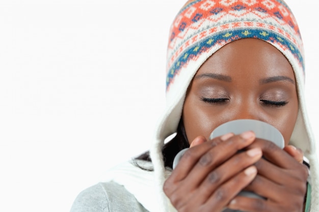 Jeune femme en dégustant une tasse de thé dans le froid