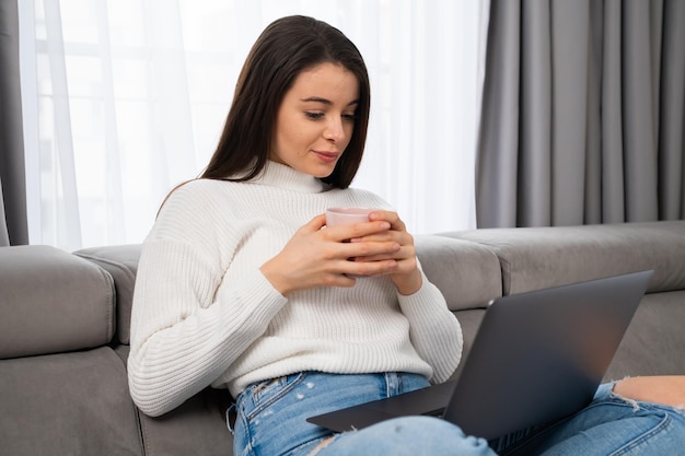 jeune femme, délassant, sofa, tenue, a, tasse