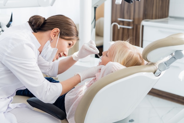 Une jeune femme dentiste effectuant un examen des dents de son patient