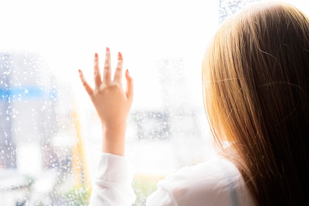 Jeune femme déprimée près de la fenêtre à la maison agrandi