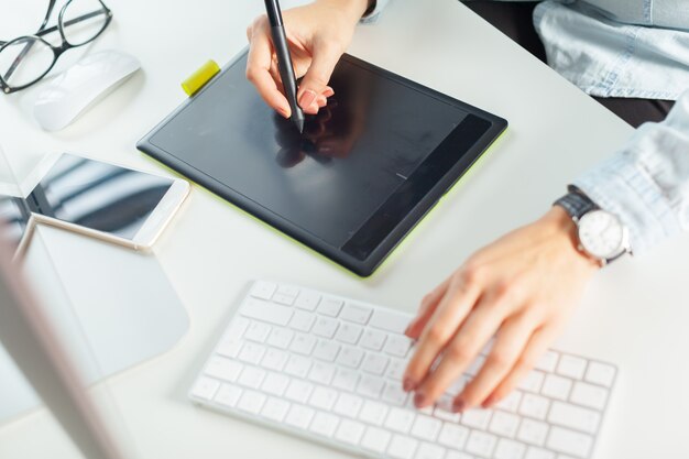 Jeune femme designer à l'aide de tablette graphique