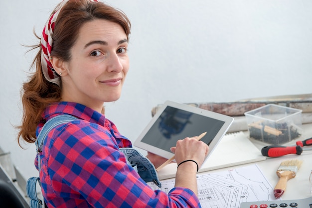 Jeune femme designer d'intérieur à l'aide de tablette numérique