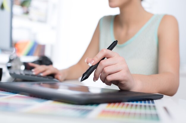 Jeune femme designer travaillant avec tablette à dessin