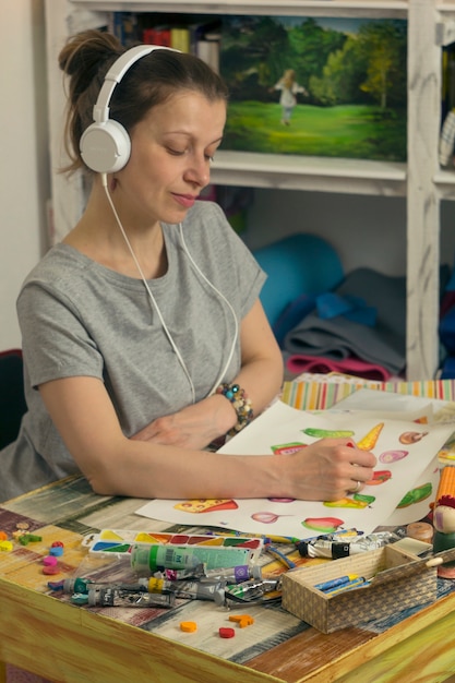 Une jeune femme dessine sur papier. Artiste sur le lieu de travail.