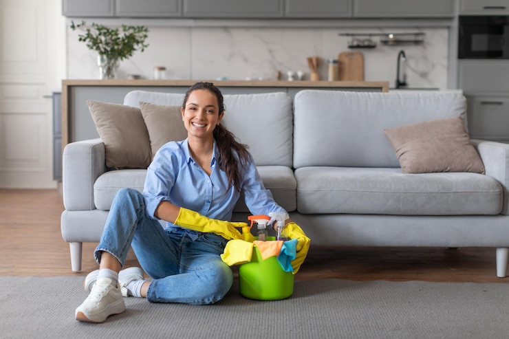 Photo une jeune femme détendue avec des fournitures de nettoyage assise sur le sol